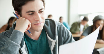 Male student taking an exam in class