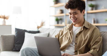 Male student studying with a notebook computer at home