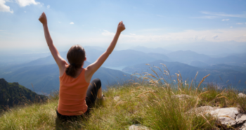 Woman sitting on top of a mountain