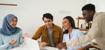 Four Students looking at a laptop