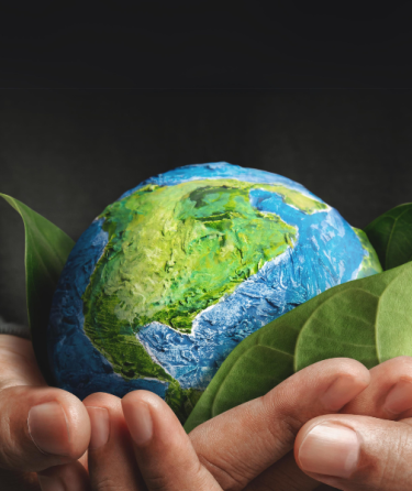 Two hands holding a small Earth