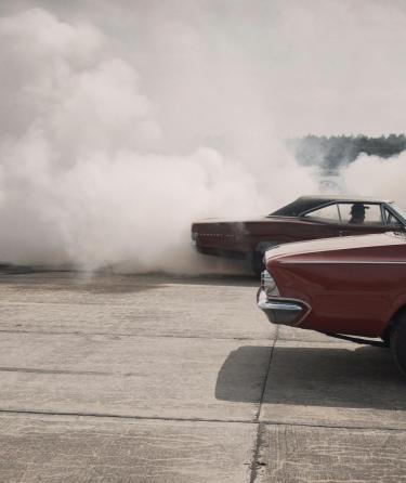 cameraman with camera on gimbal films cars doing burnout