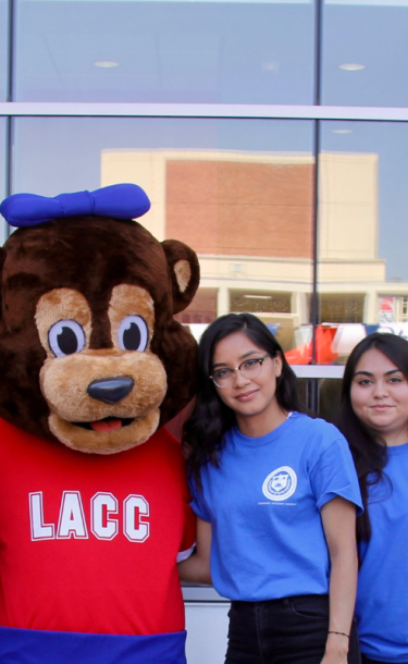 Cubby mascot standing with a group of students