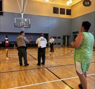 Sheriff's personnel playing basketball with students