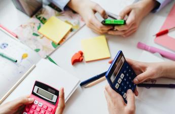 Students sit around a table using calculators