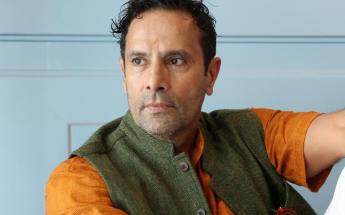 Tarsem Singh, LACC Alumni and Director, sitting on a couch and looking off camera