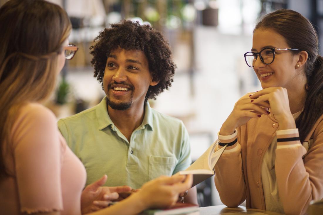 Three students discussing a book