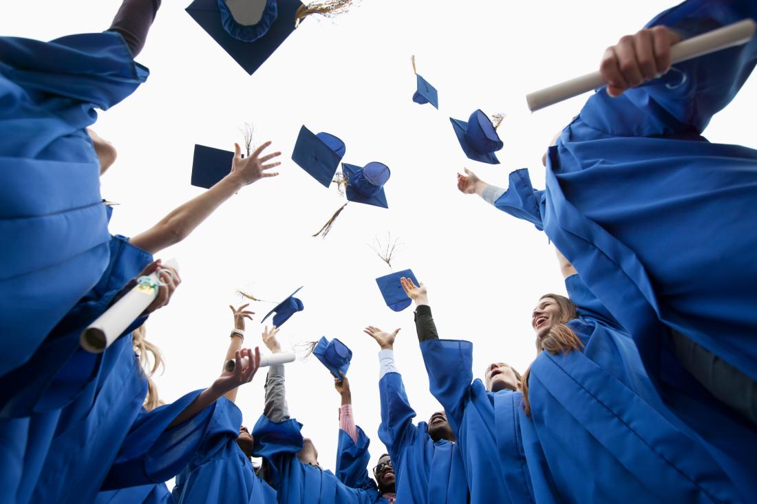 Graduating students throwing caps into the air