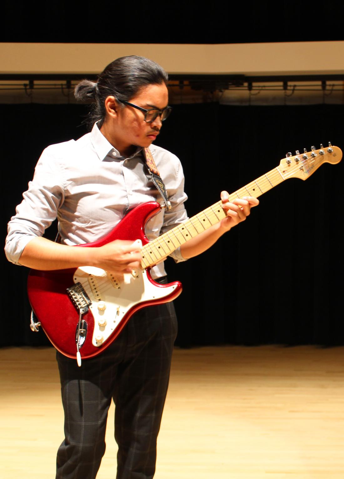 A student plays a Fender Stratocaster on the Alpert Recital Hall stage.