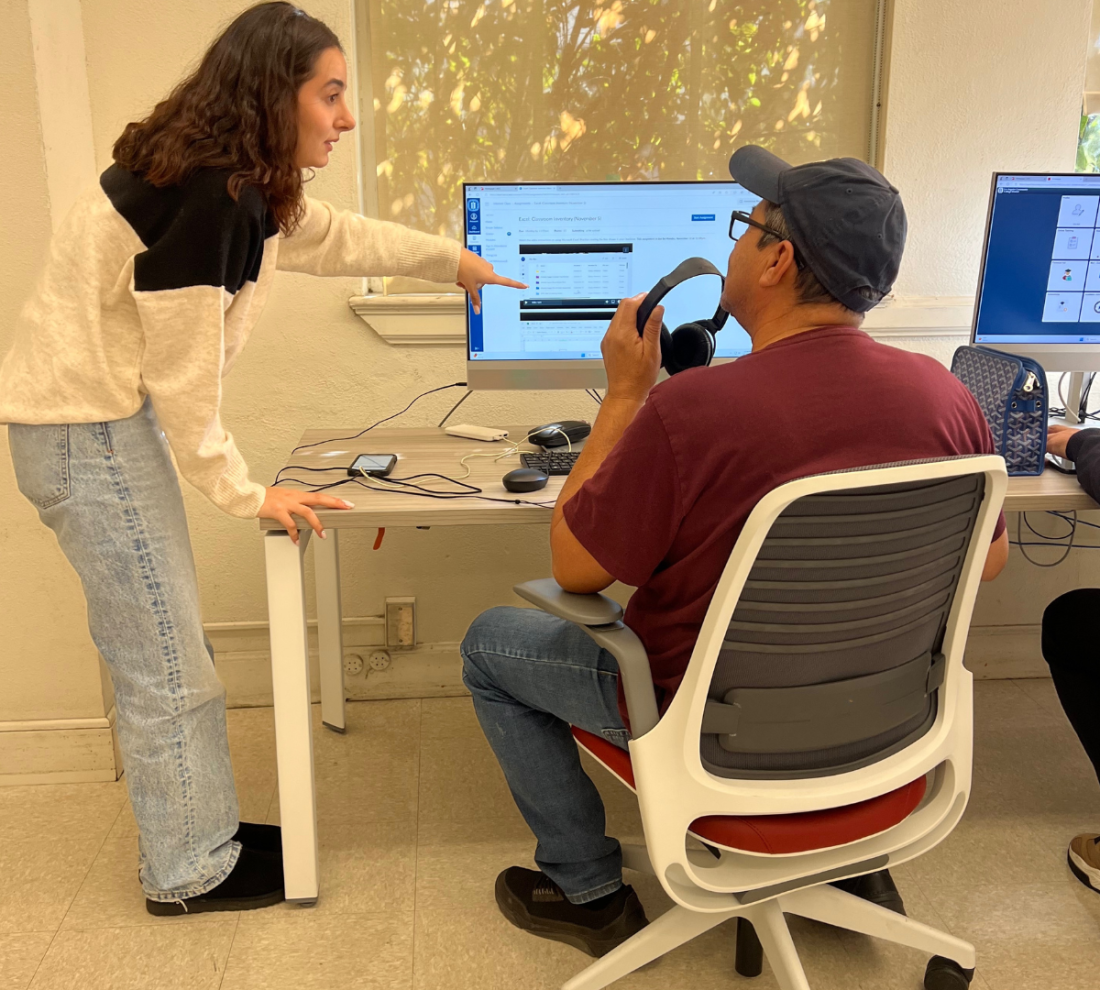 Learning center tutor helping a student on the computer