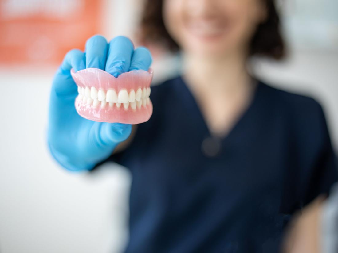 Nurse holding denture