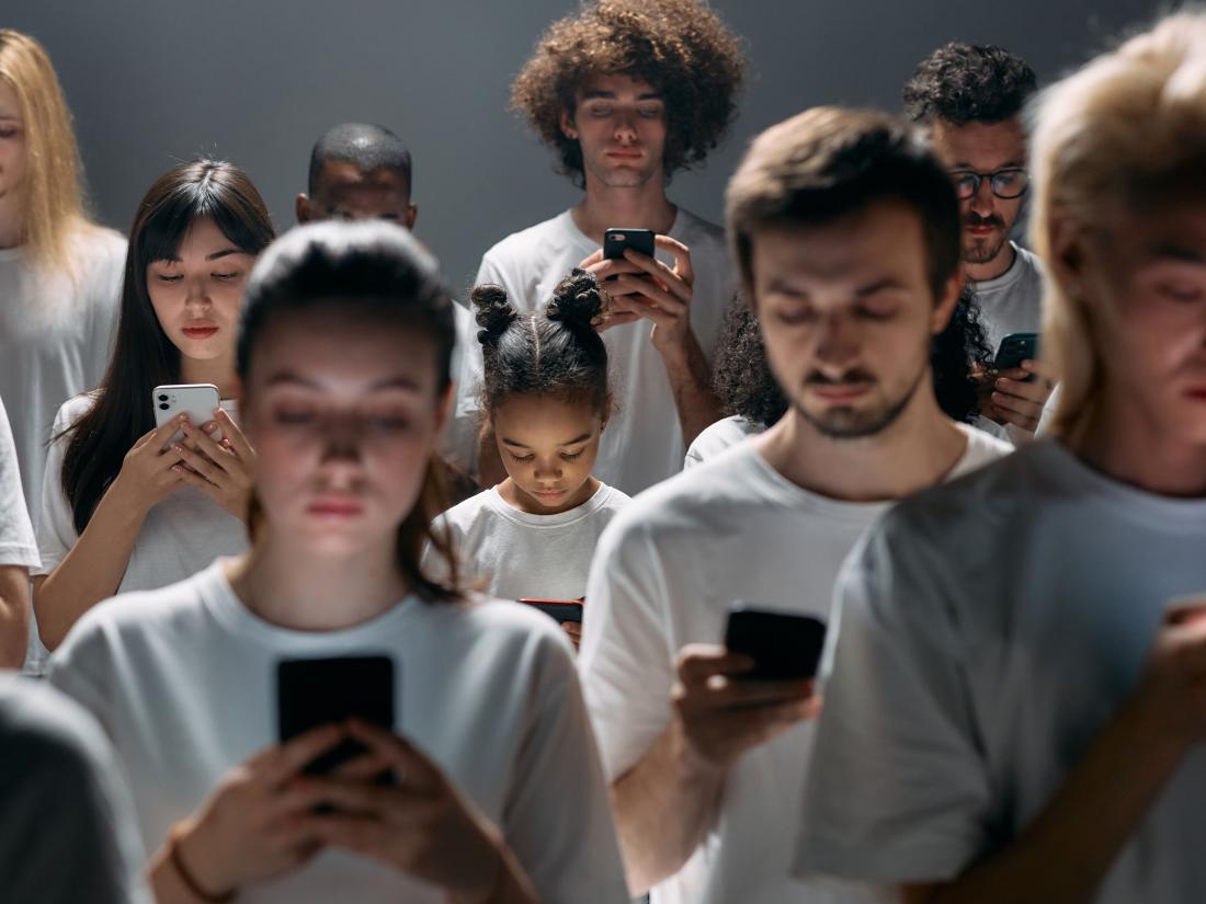 Group of people all looking at their cellphone.