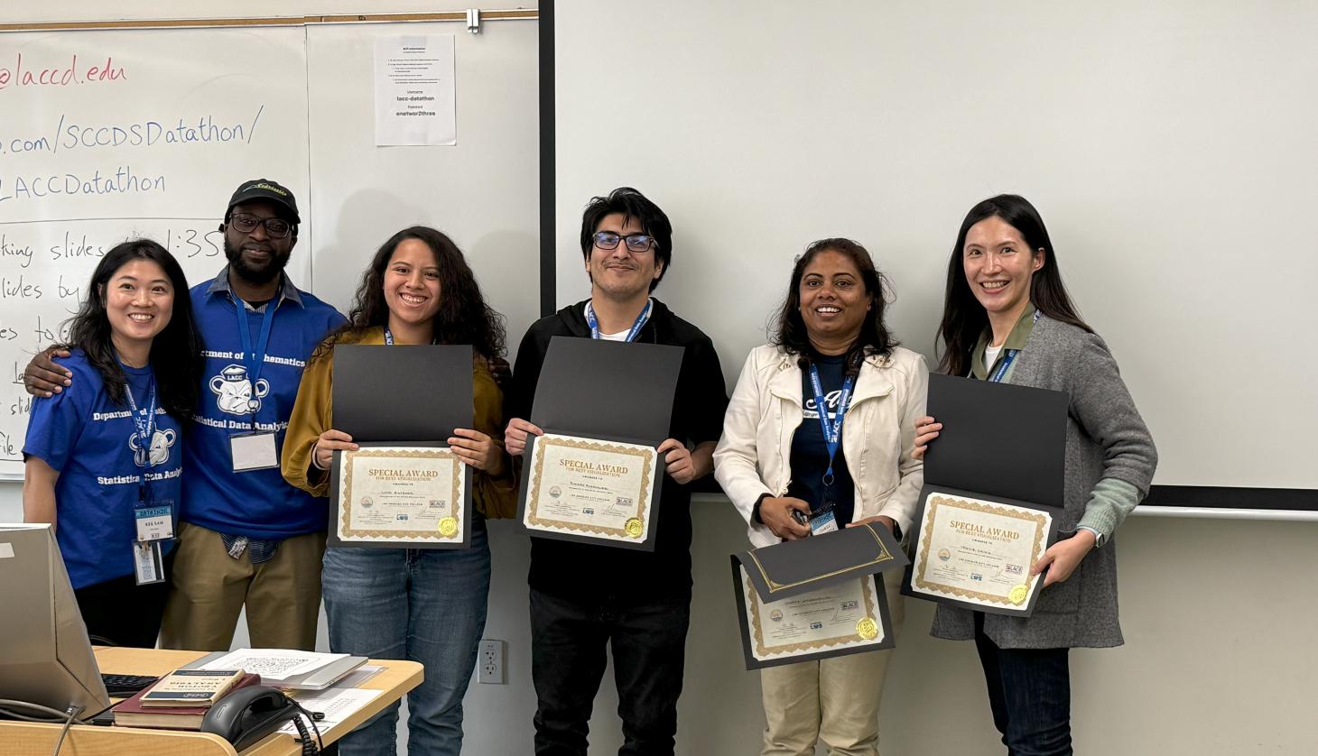 Faculty stands with students and their certificates